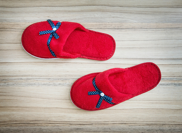 Zapatillas rojas con cinta azul en el fondo de madera
 - Foto, Imagen