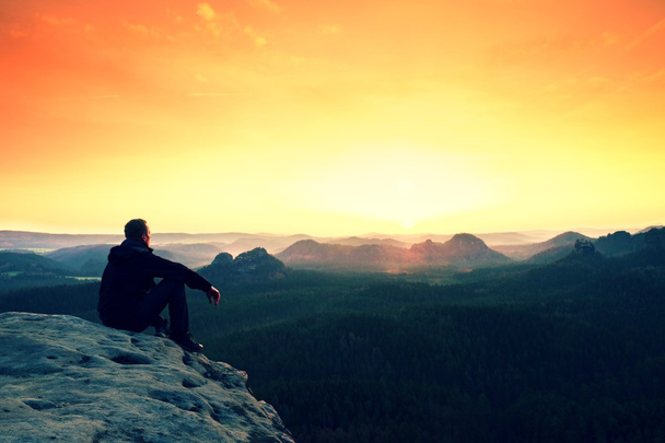 Homme enjoignant regarder le lever du jour orange dans les montagnes
 - Photo, image