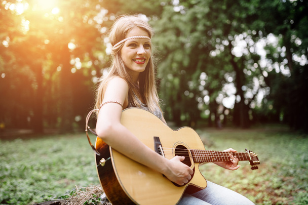 Beautiful hippie girl playing guitar - 写真・画像