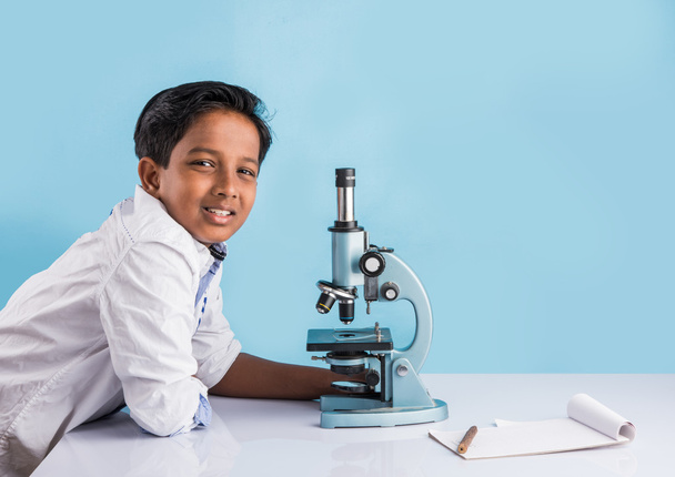 indischer Junge und Mikroskop, asiatischer Junge mit Mikroskop, süßes kleines Kind mit Mikroskop, 10-jähriger indischer Junge und naturwissenschaftliches Experiment, Junge macht naturwissenschaftliche Experimente - Foto, Bild