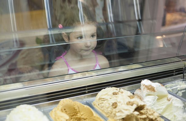 Little girl wishes ice cream in pastry shop - Photo, Image