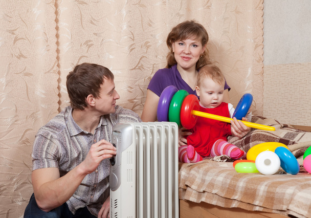 Family at home near oil heater - Valokuva, kuva