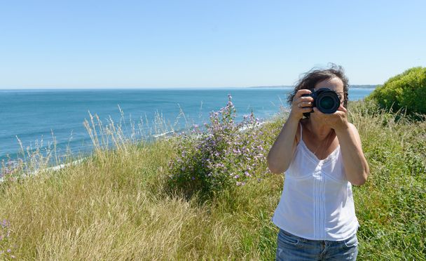 γυναίκα, φωτογραφίζοντας με την κάμερα στη θάλασσα - Φωτογραφία, εικόνα