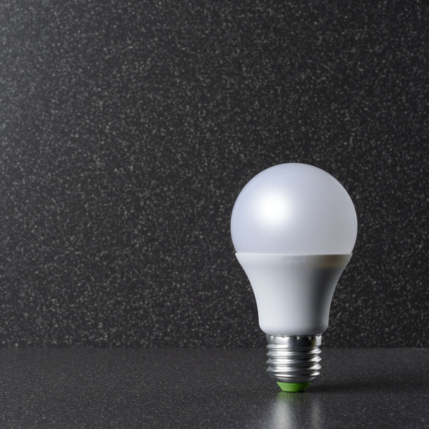 LED bulb standing on a ceramic tile - Photo, Image