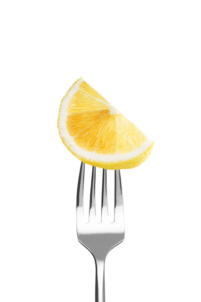 Fresh lemon on a fork - Фото, зображення