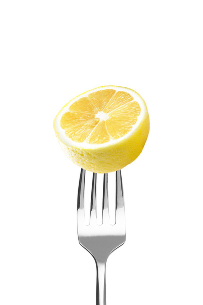 Fresh lemon on a fork - 写真・画像