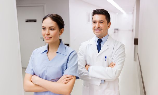 smiling doctor in white coat and nurse  - Photo, image