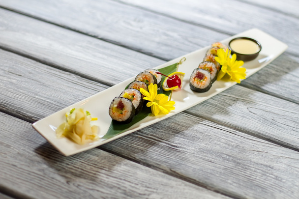 Yellow flowers on sushi plate. - Photo, Image