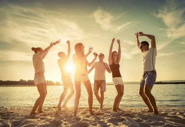De grappige dans vrienden op het strand  - Foto, afbeelding