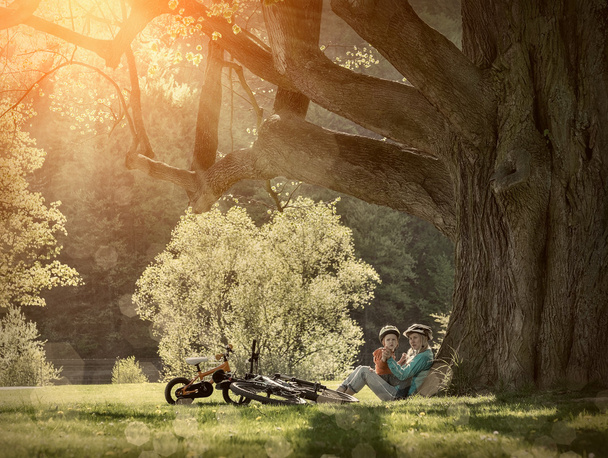 Mother and son with bicycles in the park - Photo, Image