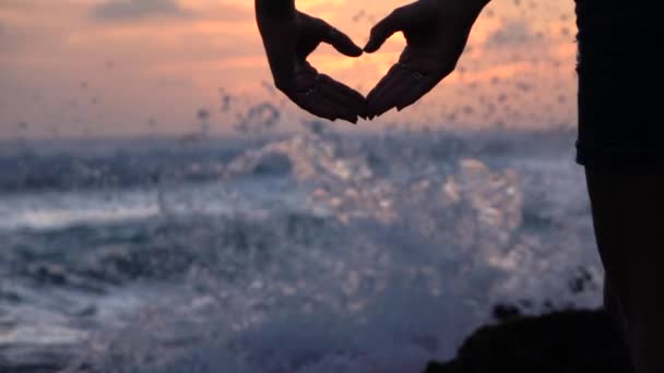 Slow Motion: jong meisje vormen hart met handen over mooie avond hemel - Video