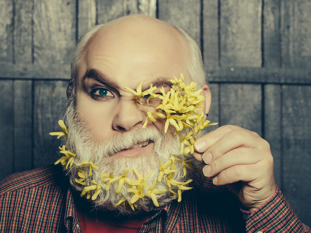 old man with flowers in beard - Фото, изображение