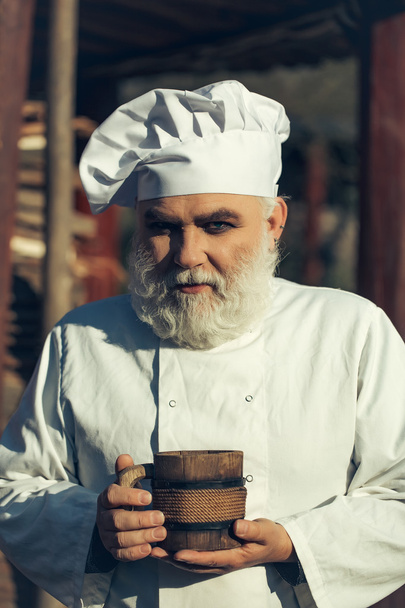 bearded cook with wooden cup - Fotoğraf, Görsel