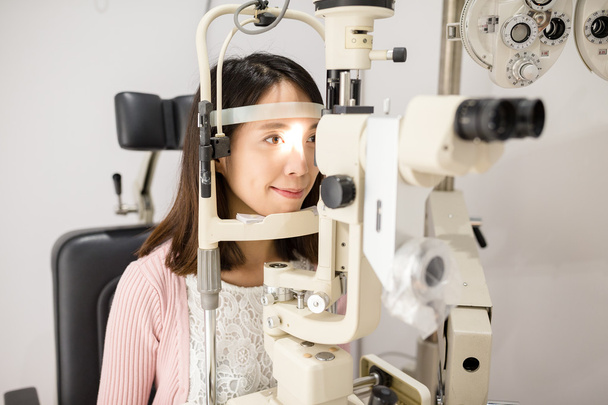 Vrouw doet oogtest in optische kliniek - Foto, afbeelding