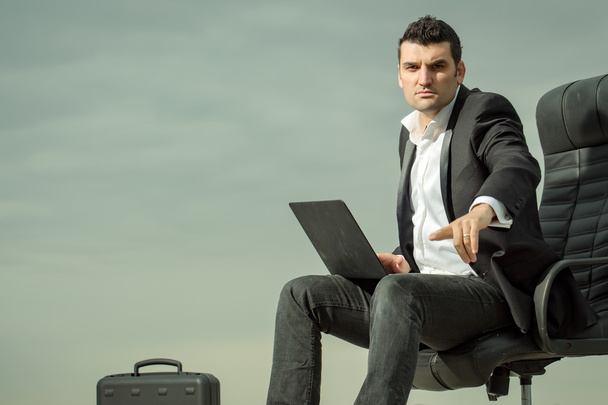 businessman with laptop on chair outdoor - Foto, Imagen