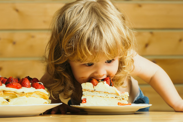 small boy eats strawberry cake - Photo, image