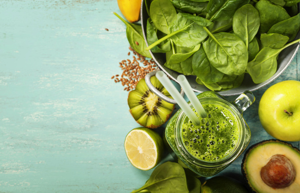 Healthy green smoothie and ingredients on blue background  - Фото, изображение