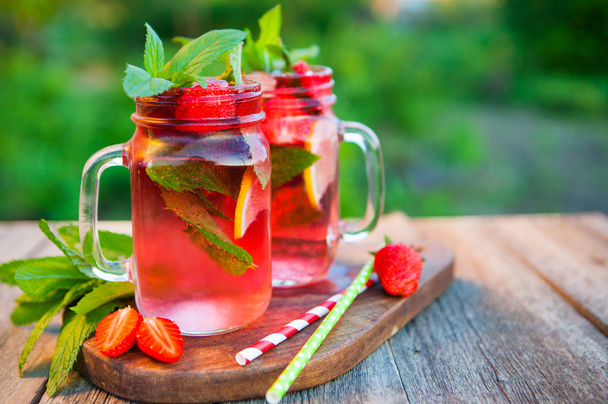 Red lemonade with strawberries and mint on an old wooden table i - Фото, зображення