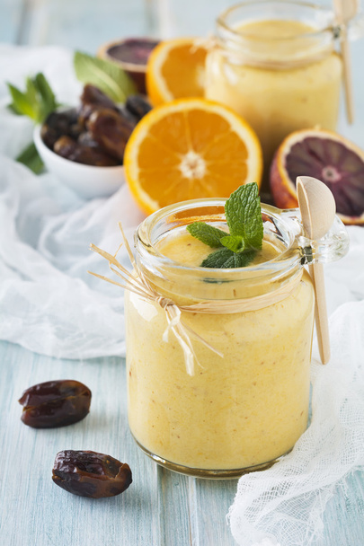 Healthy and fresh orange and date fruit smoothie on blue wooden table. Selective focus. - Foto, Imagen