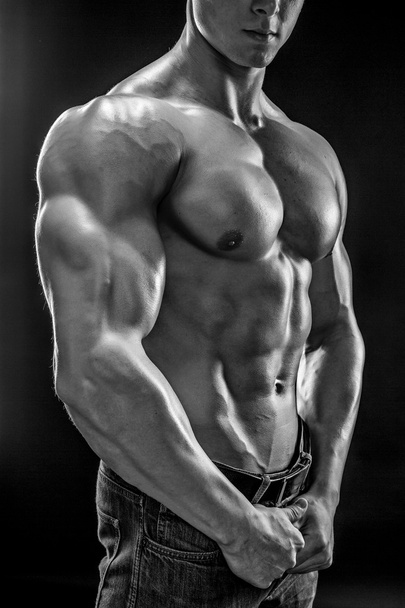 Μυϊκή bodybuilder τύπος κάνει που παρουσιάζουν πάνω από το μαύρο φόντο - Φωτογραφία, εικόνα