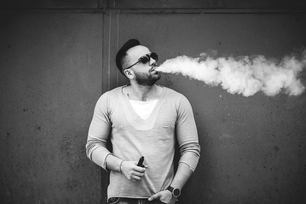 Man in sunglasses vaping outdoor - Photo, image
