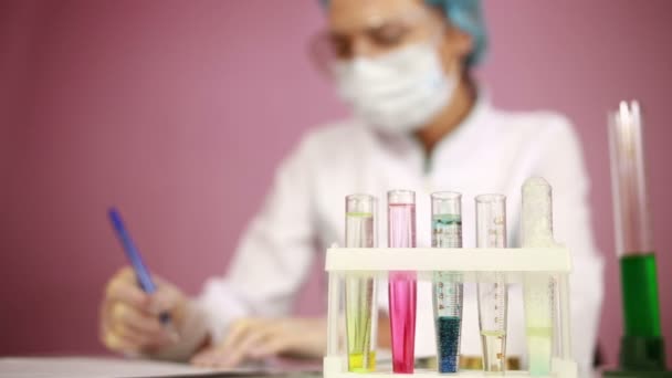Kadın kimyacı test tüpleri kimyasallar ile karşılaştırma. koruyucu gözlük - Video, Çekim