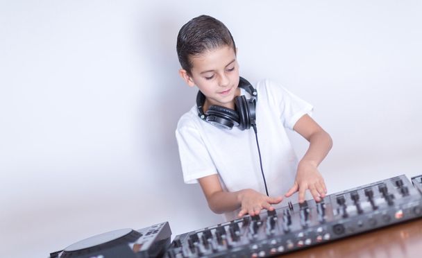 Menino DJ em fones de ouvido misturando alguma música de festa
 - Foto, Imagem