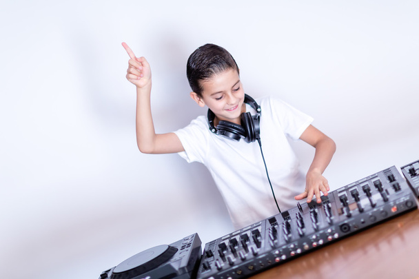 Pequeño niño DJ en auriculares mezclando un poco de música de fiesta
 - Foto, Imagen