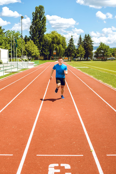 Running fast on athletic field track. - Fotó, kép