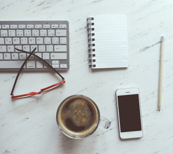 Χώρο εργασίας με το σημειωματάριο, καφέ, smartphone, γυαλιά και πληκτρολόγιο - Φωτογραφία, εικόνα
