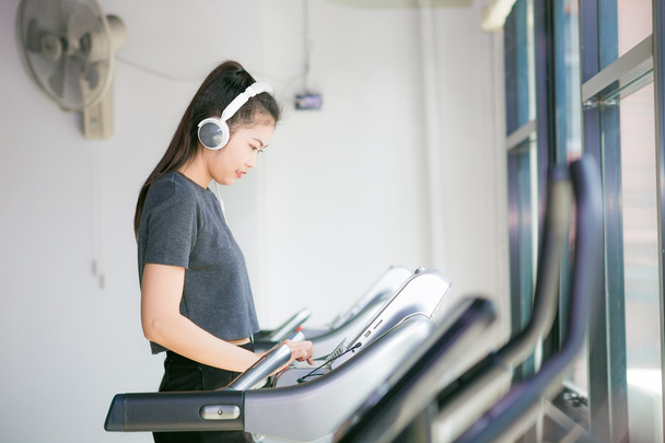 Attractive asian women running on the treadmill in the gym - Photo, Image