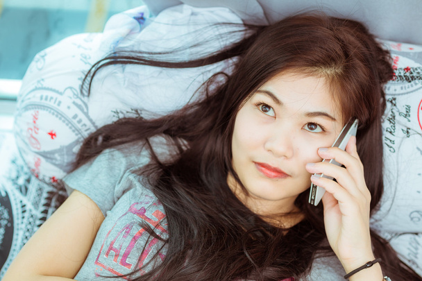 Mujer en la cama revisando aplicaciones sociales con smartphone
 - Foto, imagen