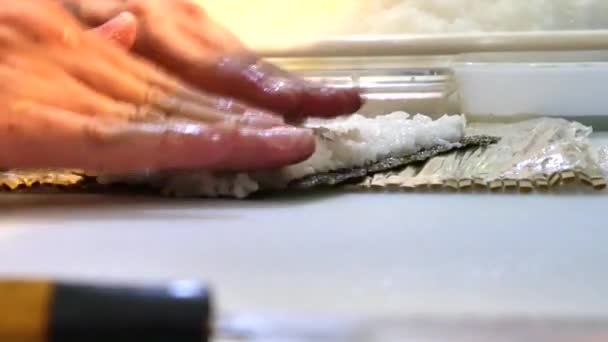 Sushi-Koch bereitet Lachspfirsich-Futomaki-Rolle zu. Ein Sushi-Mann kocht Lachs, Avocado, Pfirsich, Garnelen und Roes Sushi-Rollen. Rezepte der japanischen Küche. Profi-Koch mit Küchenutensilien. - Filmmaterial, Video