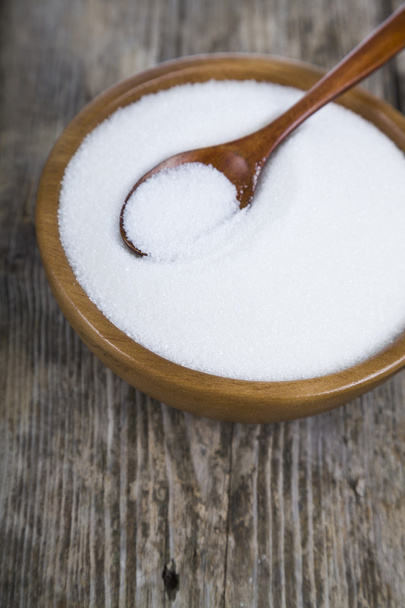 Sugar and spoon in a wooden bowl   - Фото, изображение
