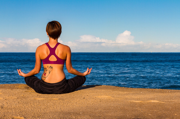 Giovane donna fa Yoga su una spiaggia
 - Foto, immagini