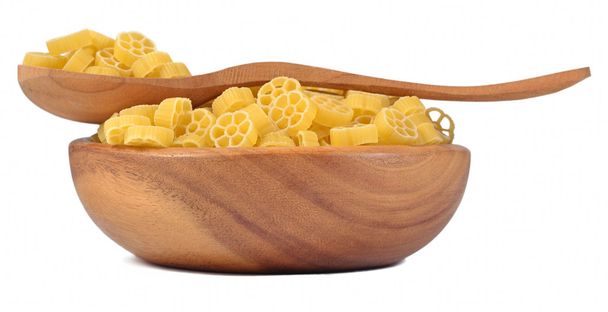 Rotelle de pâtes italiennes non cuites dans un bol en bois sur un blanc
 - Photo, image