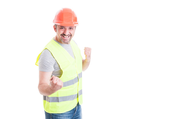 Glimlachend opgewonden bouwer gedraagt zich als een winnaar - Foto, afbeelding