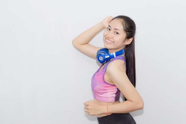 Nuori urheilu Nainen kuulokkeissa kuuntelee musiikkia ja hymyilee
 - Valokuva, kuva