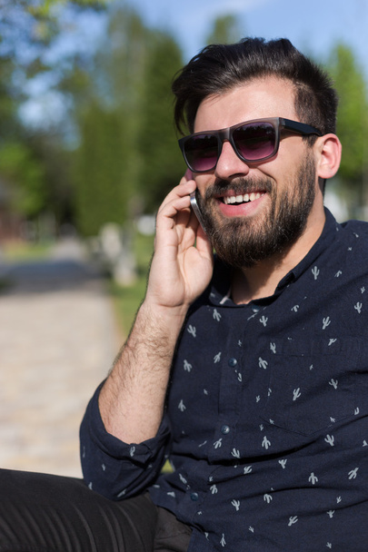 Young bearded man talking on smartphone  - Foto, afbeelding