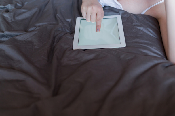Woman using tablet in bed - Foto, afbeelding
