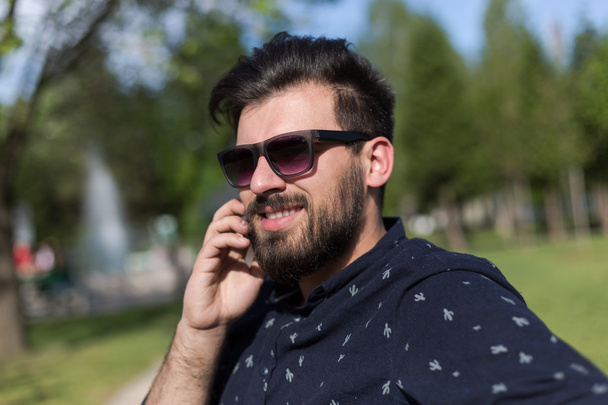 Young bearded man talking on smartphone  - Photo, Image