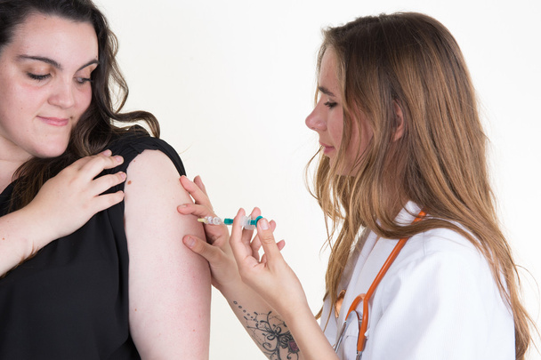 вакцинация: женщина-врач вводит вакцину, изолированную на белом
 - Фото, изображение