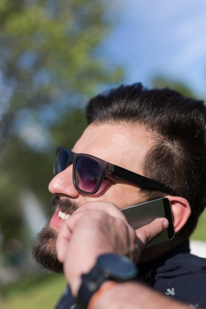 Young bearded man talking on smartphone  - 写真・画像