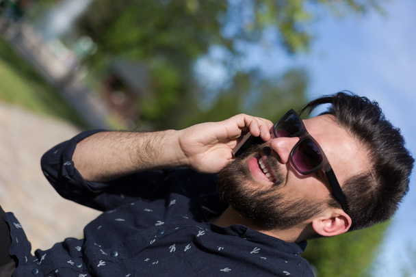 Young bearded man talking on smartphone  - Fotoğraf, Görsel