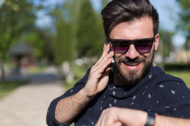 Young bearded man talking on smartphone  - Zdjęcie, obraz