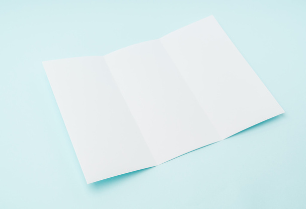 Trifold white template paper on blue background . - Foto, immagini