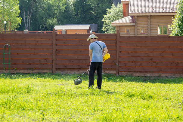 man mows the grass with string trimmer - Zdjęcie, obraz