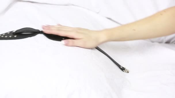female hand takes fetish mask. sex toys. white sheets - Záběry, video
