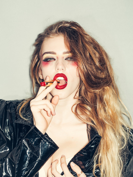 Pretty woman with lipstick in mouth - Foto, afbeelding