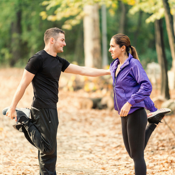 Happy couple exercising in park - Photo, image
